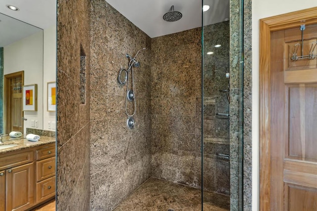 bathroom with vanity and a tile shower