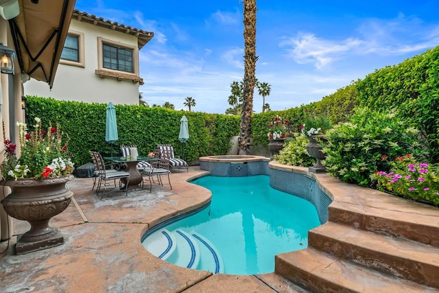 view of pool featuring a patio area and an in ground hot tub