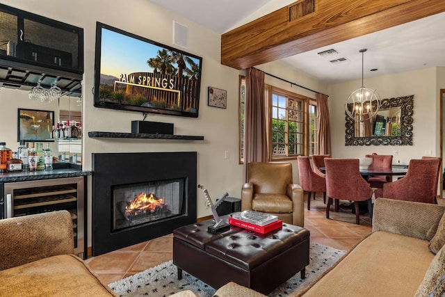 living room with bar area, light tile patterned flooring, wine cooler, and a chandelier