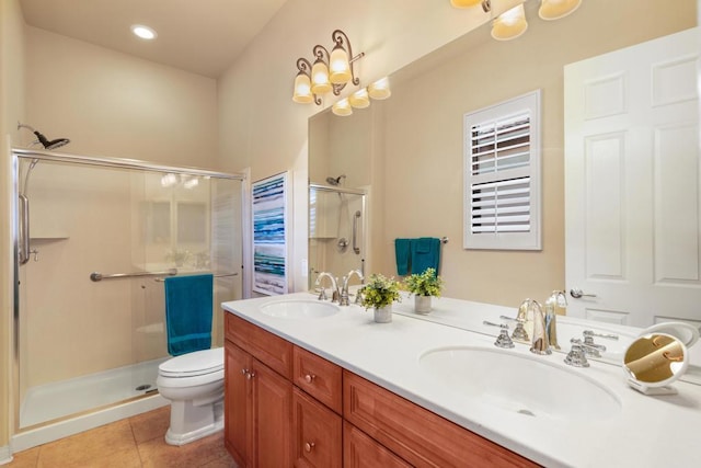 bathroom featuring toilet, vanity, a shower with door, and tile patterned flooring