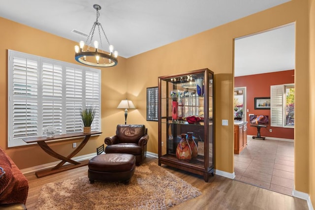 living area with a chandelier and light hardwood / wood-style flooring