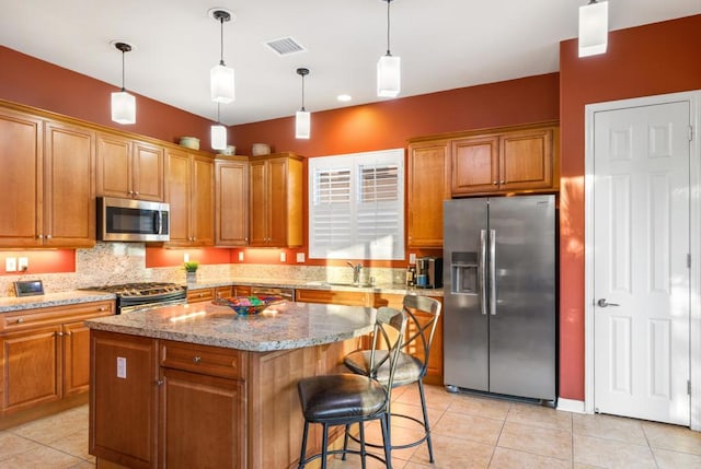 kitchen with pendant lighting, sink, appliances with stainless steel finishes, a center island, and light tile patterned flooring