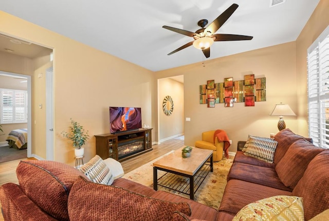 living room featuring ceiling fan and light wood-type flooring