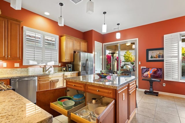 kitchen featuring pendant lighting, light tile patterned floors, a kitchen island, and appliances with stainless steel finishes