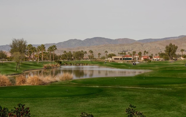 view of property's community featuring a water and mountain view and a yard