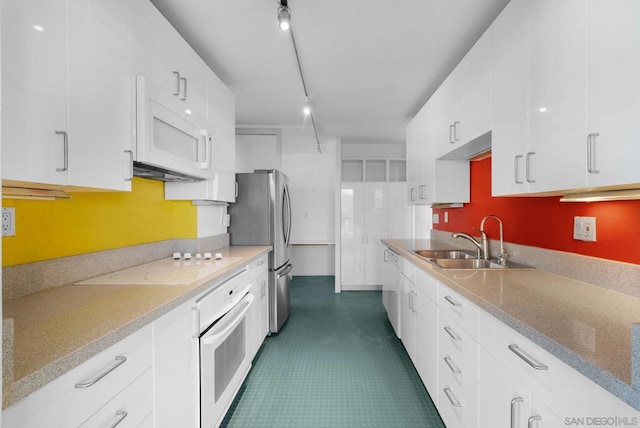 kitchen with white cabinetry, sink, and white appliances