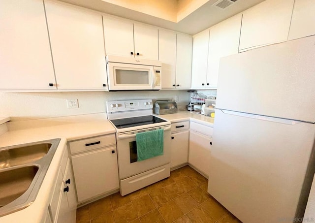 kitchen featuring tile patterned flooring, white appliances, white cabinetry, and sink