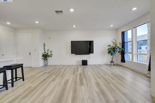 living room featuring a healthy amount of sunlight and light hardwood / wood-style floors