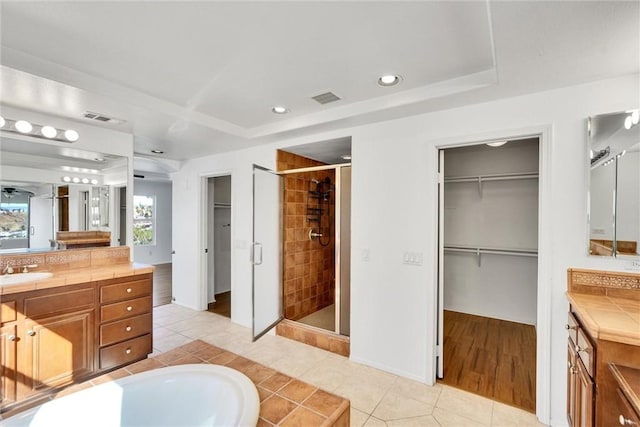 bathroom with a stall shower, visible vents, and vanity