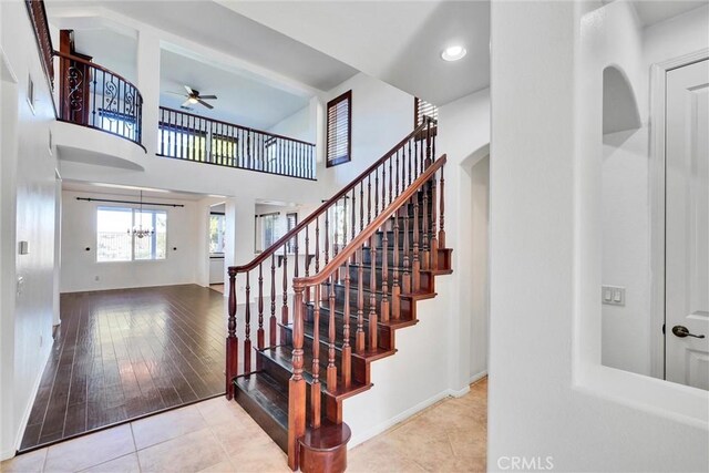 stairway with tile patterned flooring and ceiling fan