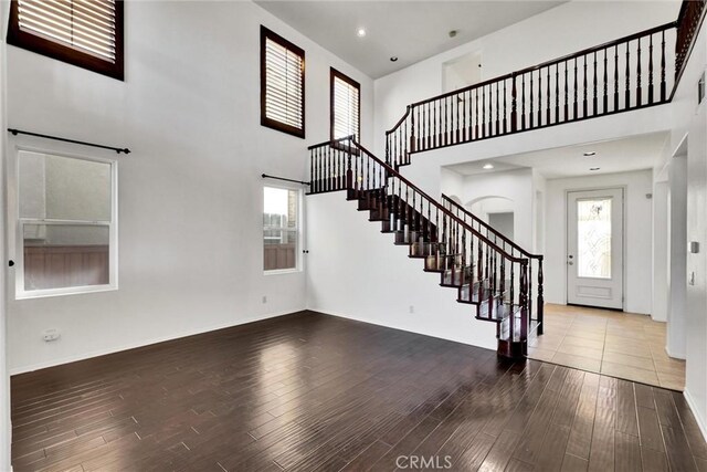 foyer with hardwood / wood-style floors and a towering ceiling