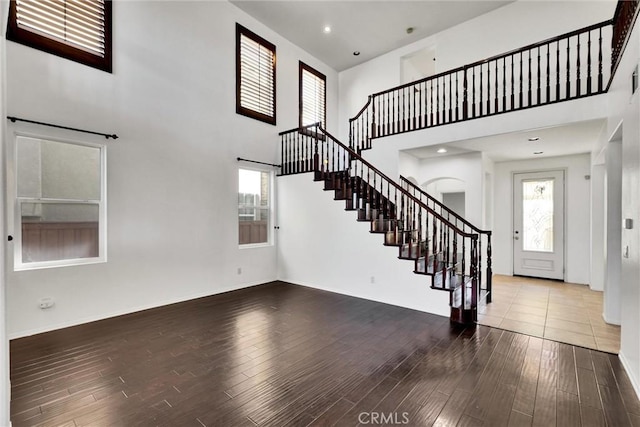 entryway with a wealth of natural light, stairway, and wood finished floors