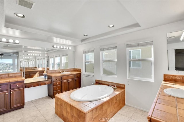 full bathroom featuring a healthy amount of sunlight, visible vents, a tray ceiling, and vanity