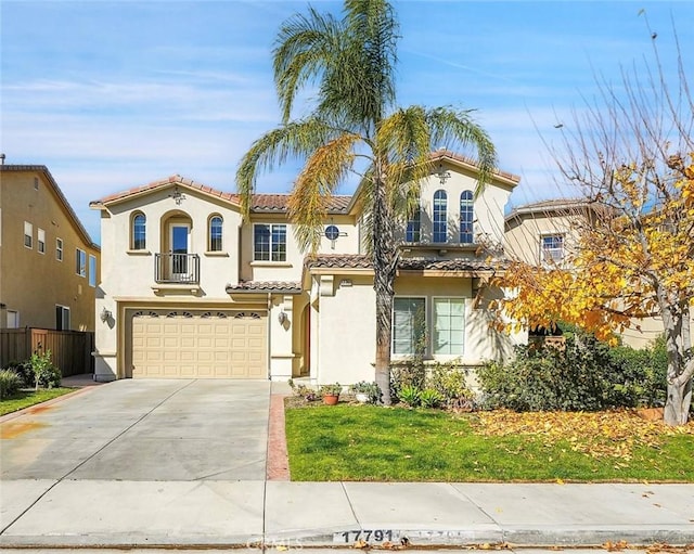 mediterranean / spanish-style house with driveway, an attached garage, a balcony, and stucco siding