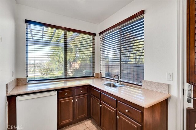 kitchen featuring sink, light tile patterned floors, and a healthy amount of sunlight