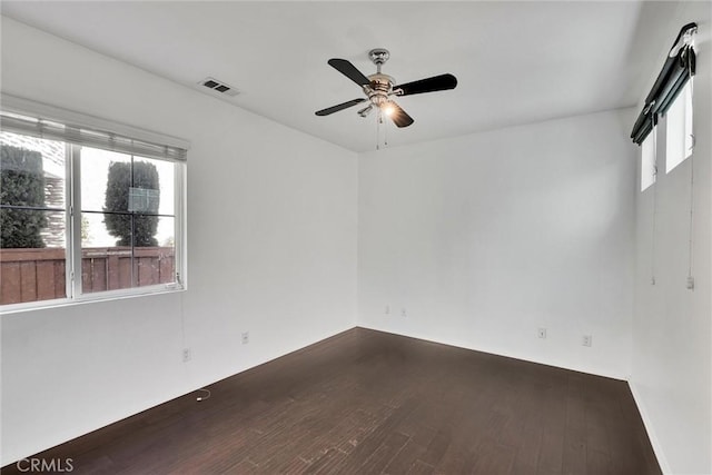 empty room with ceiling fan and dark wood-type flooring