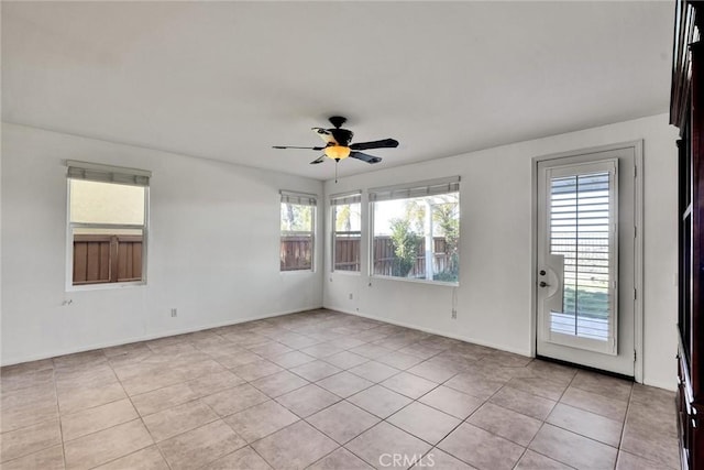 unfurnished room featuring a healthy amount of sunlight, a ceiling fan, and light tile patterned flooring