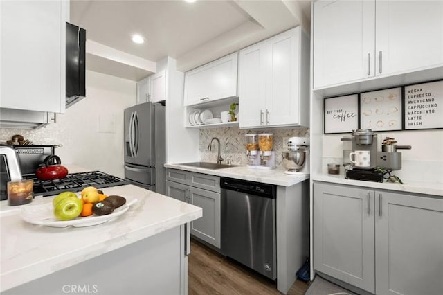 kitchen featuring tasteful backsplash, sink, gray cabinetry, stainless steel appliances, and light stone countertops