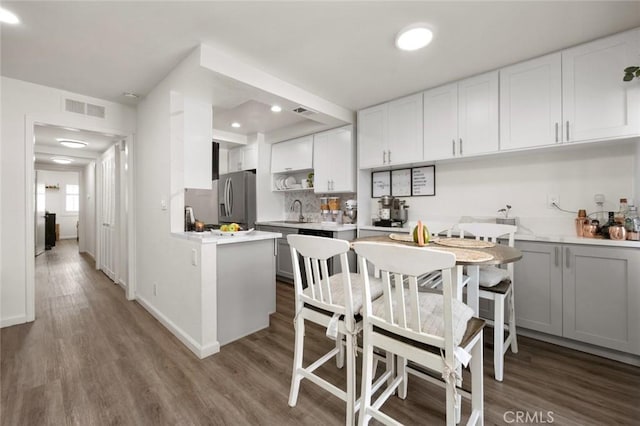 kitchen featuring stainless steel fridge with ice dispenser, wood-type flooring, sink, and white cabinets