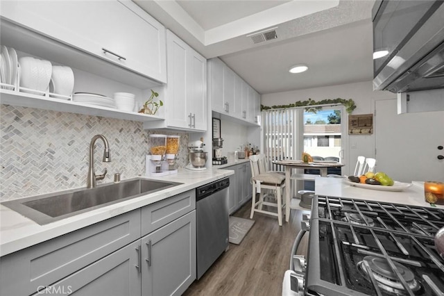 kitchen with sink, gray cabinetry, backsplash, dark hardwood / wood-style flooring, and stainless steel appliances