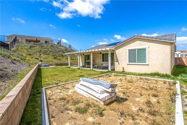 back of house with ceiling fan, a yard, and a patio