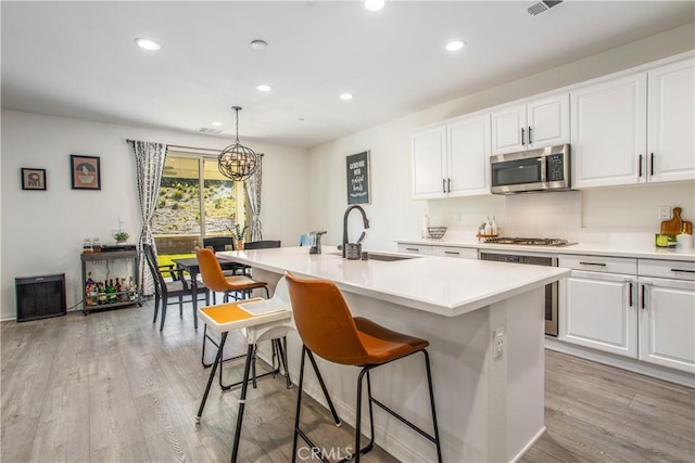 kitchen with sink, white cabinets, a center island with sink, and appliances with stainless steel finishes