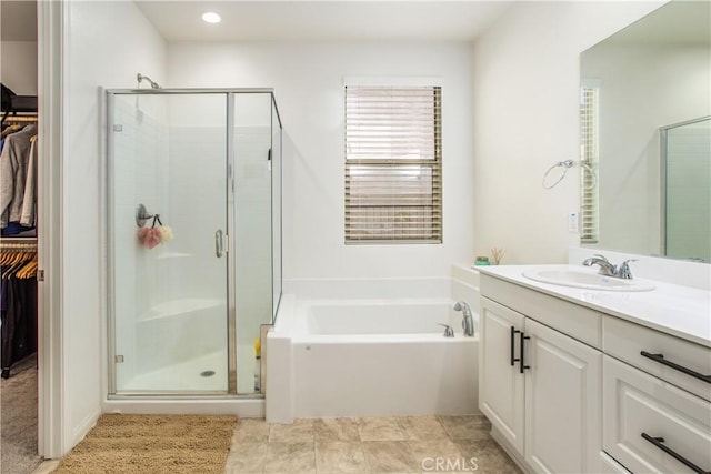 bathroom featuring shower with separate bathtub and vanity