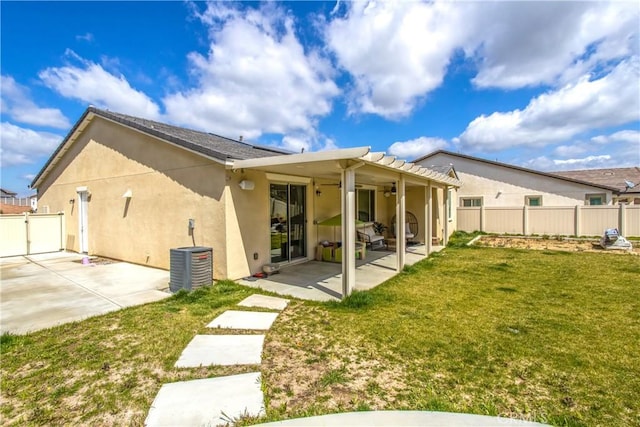 rear view of property with central AC, a patio area, and a lawn