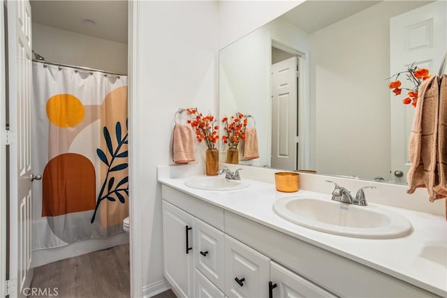 bathroom with hardwood / wood-style floors, vanity, and toilet