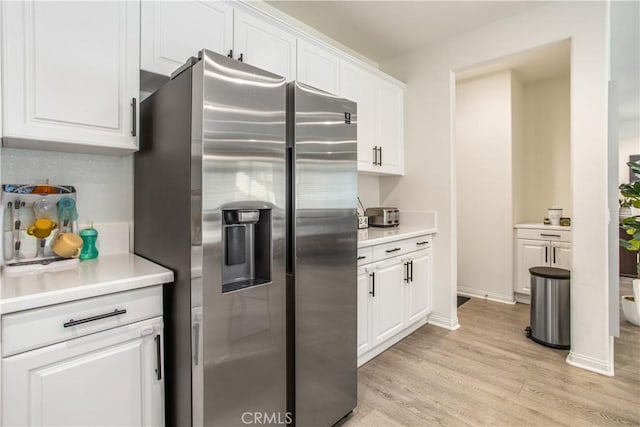 kitchen featuring stainless steel fridge with ice dispenser, white cabinets, and light hardwood / wood-style floors