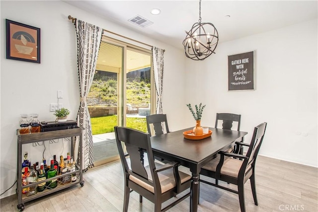 dining room featuring light hardwood / wood-style flooring and a notable chandelier