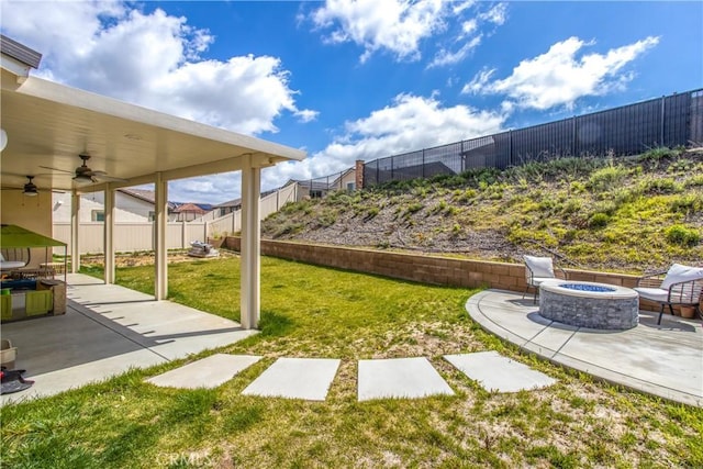 view of yard featuring ceiling fan, a patio, and an outdoor fire pit