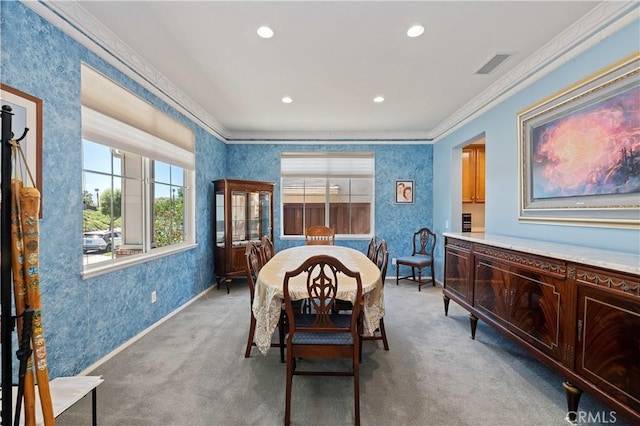 carpeted dining space featuring crown molding