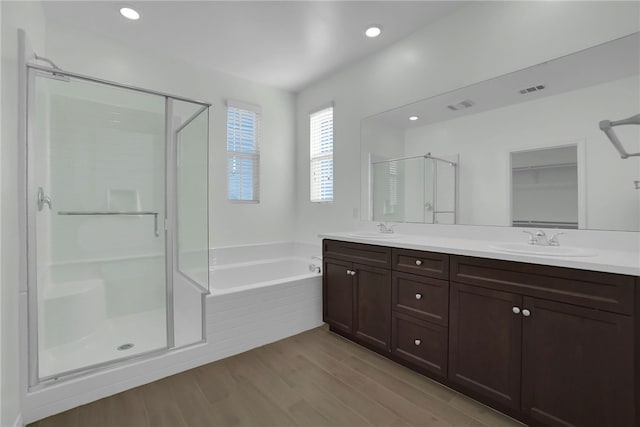 bathroom featuring vanity, wood-type flooring, and shower with separate bathtub