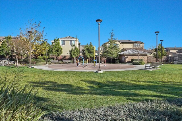 view of property's community featuring a patio area and a lawn