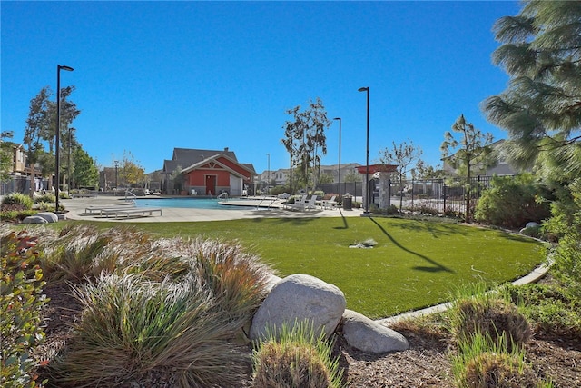 view of community with a lawn, a patio area, and a pool