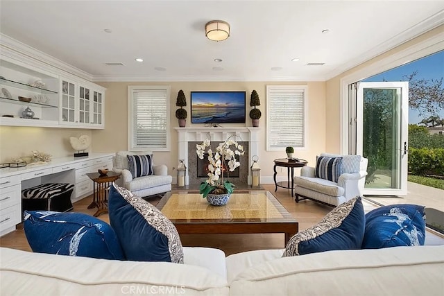 living room with a fireplace, crown molding, and light hardwood / wood-style flooring