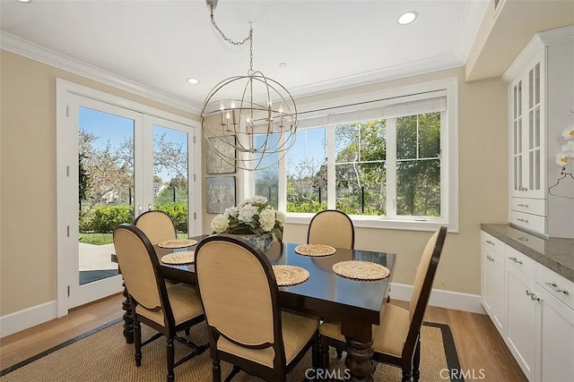 dining space featuring hardwood / wood-style floors, plenty of natural light, ornamental molding, and french doors