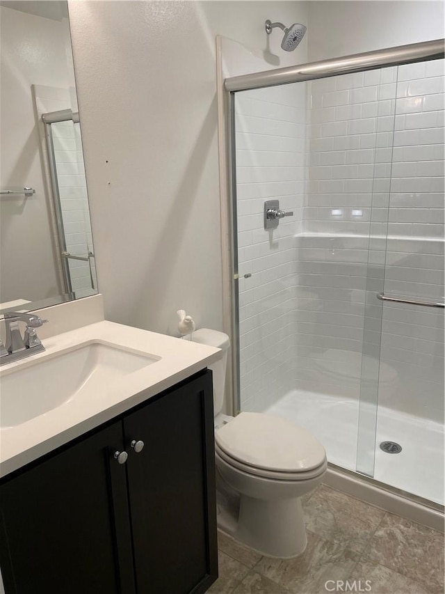 bathroom with vanity, toilet, and an enclosed shower