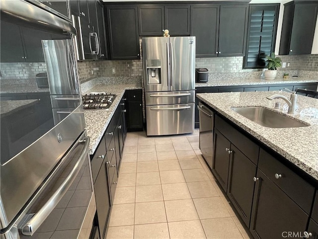 24445 Paxton Ln, Lake Elsinore, CA 92532 - kitchen featuring backsplash, appliances with stainless steel finishes, a sink, light tile patterned floors, and dark cabinets