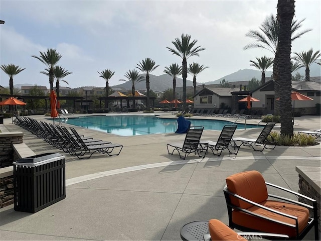 view of swimming pool with a mountain view and a patio