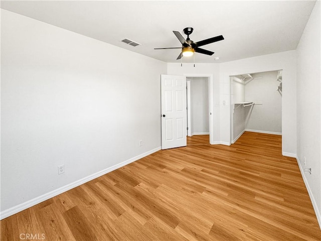 unfurnished bedroom with ceiling fan, light hardwood / wood-style flooring, and a closet