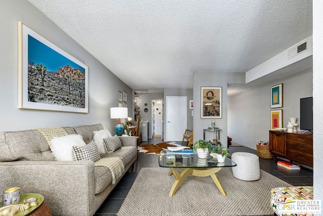 living room featuring dark tile patterned flooring and a textured ceiling