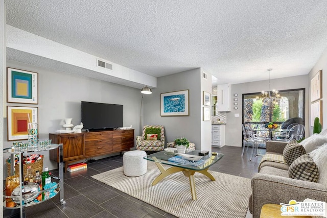 living room with a textured ceiling and a notable chandelier