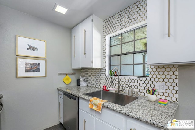 kitchen featuring stainless steel dishwasher, white cabinets, and sink