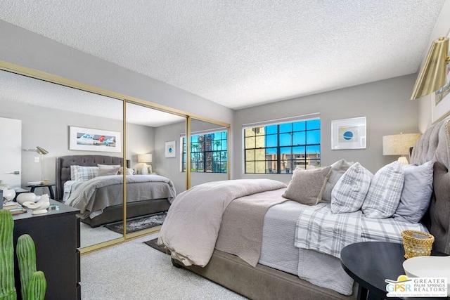 carpeted bedroom with a closet and a textured ceiling