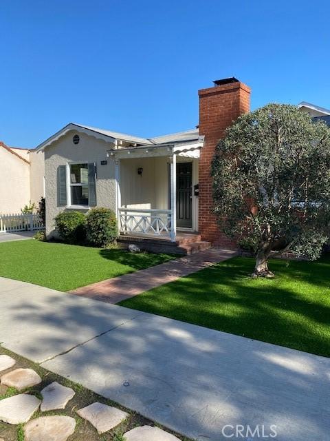 view of front of house with a front yard and covered porch