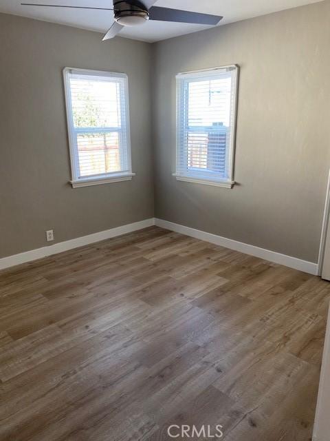 unfurnished room with hardwood / wood-style flooring and ceiling fan