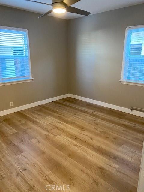 unfurnished room featuring hardwood / wood-style floors and ceiling fan