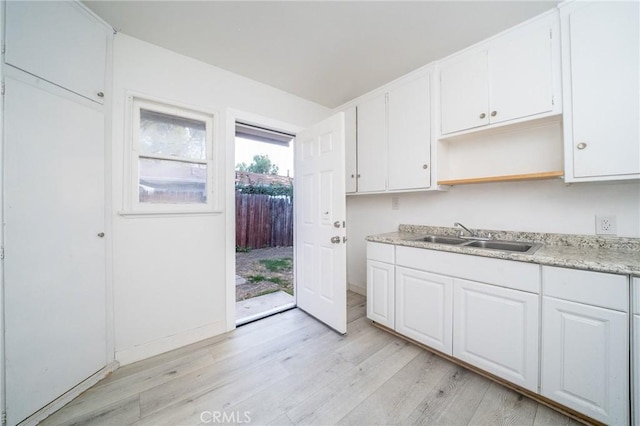 kitchen featuring white cabinetry, sink, and light hardwood / wood-style flooring